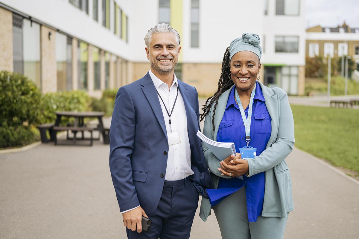 Portrait of cheerful teachers on secondary school campus